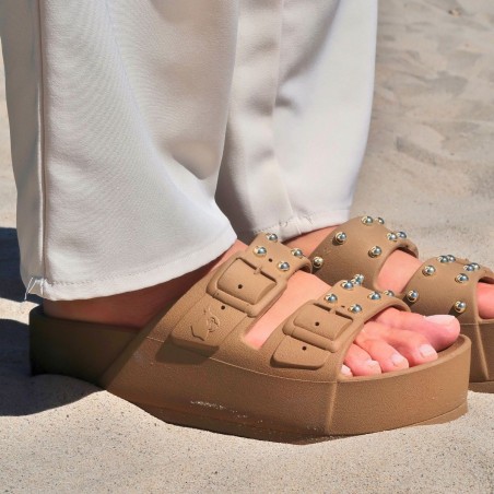 sandales compensées marron à clous cacatoès vues de profil portées femme dans le sable